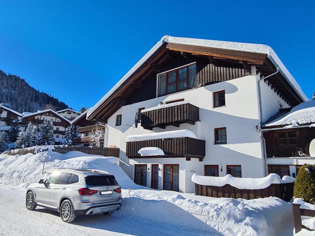 a car parked in front of a house in the snow at Alpine Vibes in Sankt Anton am Arlberg