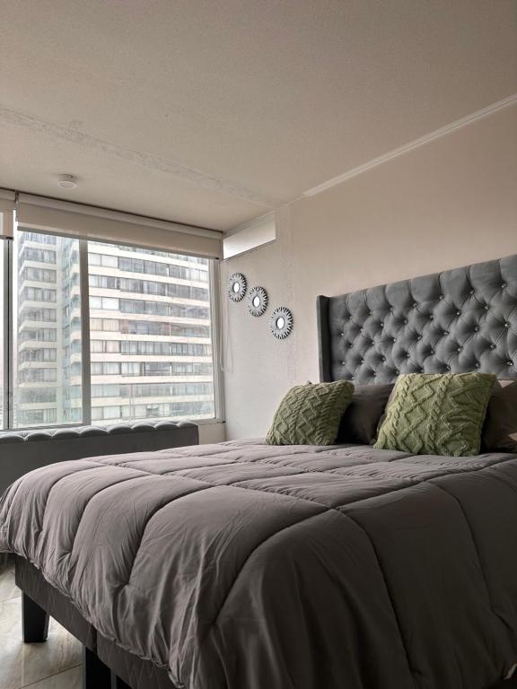 um quarto com uma cama grande e uma janela grande em Boulevard frente a la playa, Central y moderno em Iquique