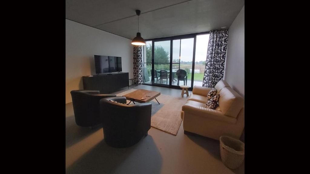 een woonkamer met een bank, stoelen en een tafel bij Ludovic - 3 bedroom apartment in Essen