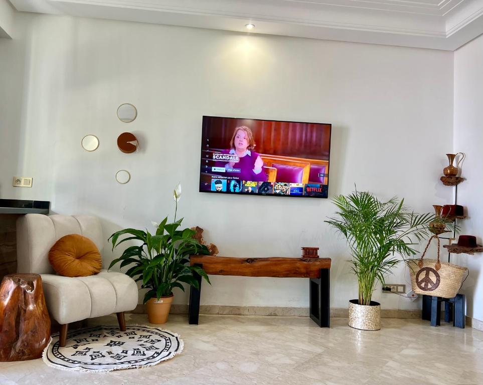 a living room with a tv on the wall at Maarif Cosy 4 lits Parking wifi Netflix Gratuit in Casablanca