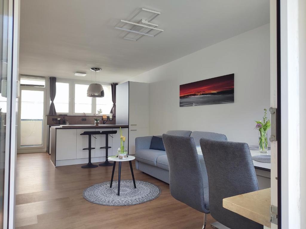 uma sala de estar com um sofá e uma mesa em 100m zum Ulmer Münster: 57m² Wohnung an der Blau em Ulm