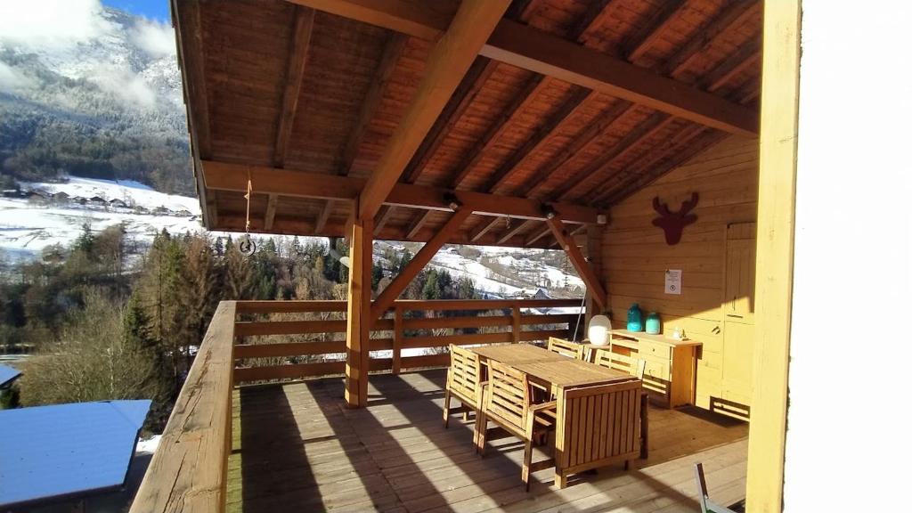 een veranda van een hut met een tafel en stoelen bij Chez Alphonse in Thônes