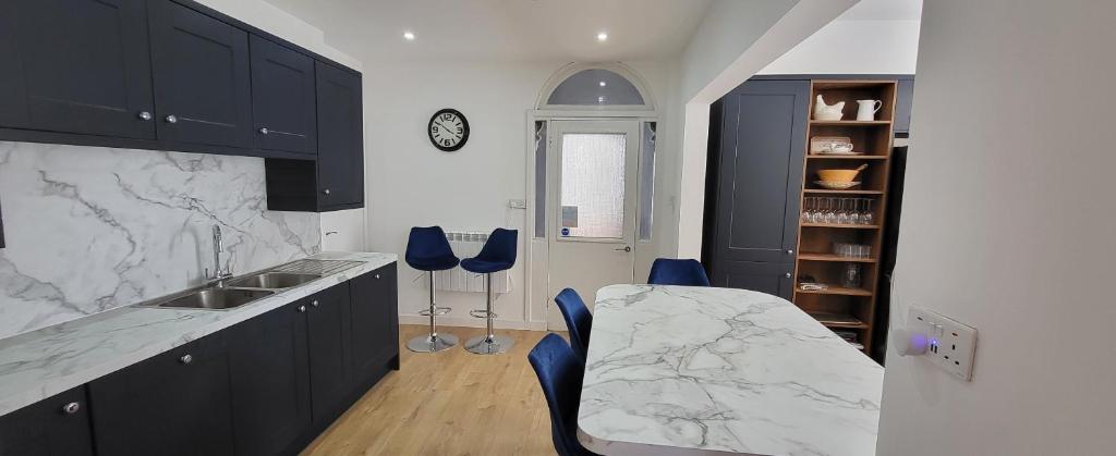 a kitchen with black cabinets and blue stools at Purbeck Lodge in Swanage