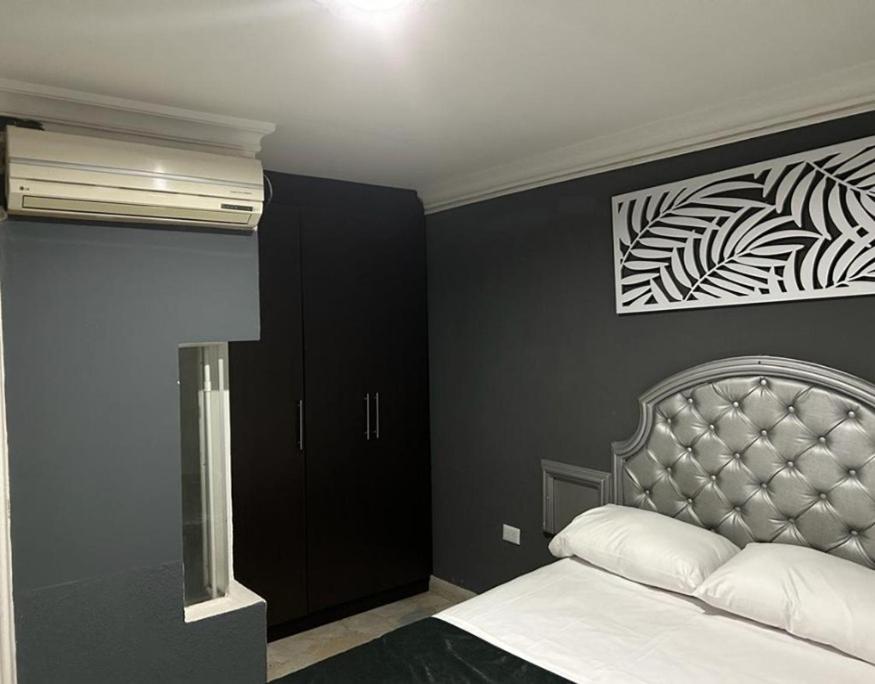 內瓦的住宿－HOTEL CASA LUKE，一间卧室设有一张床和黑色的墙壁