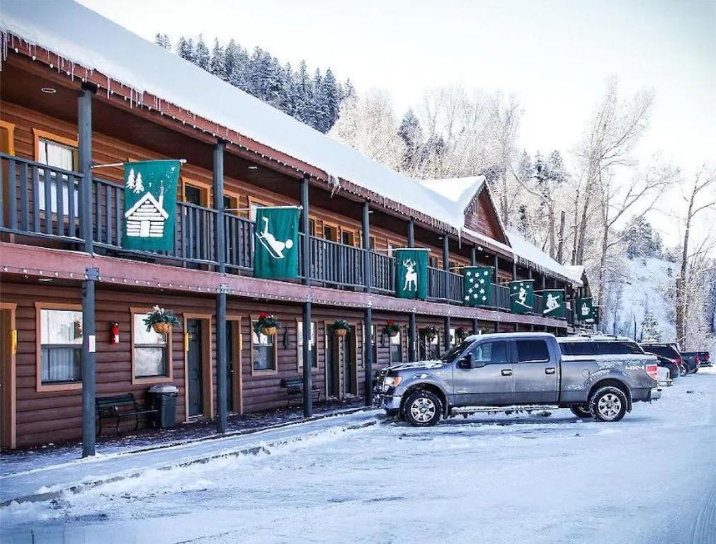 a truck parked in front of a building in the snow at High Creek Lodge and Cabins in Pagosa Springs