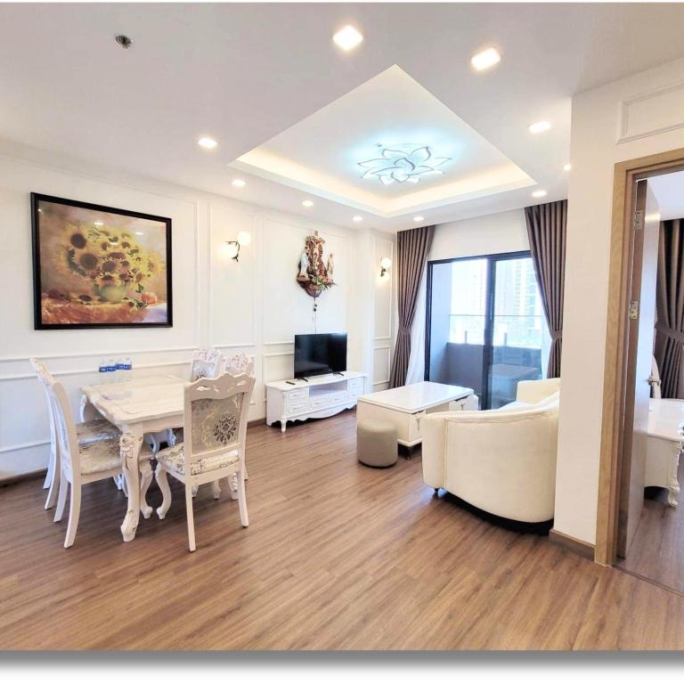 a living room with a dining table and a living room with a couch at FLC Luxury Apartment Quy Nhon in Quy Nhon