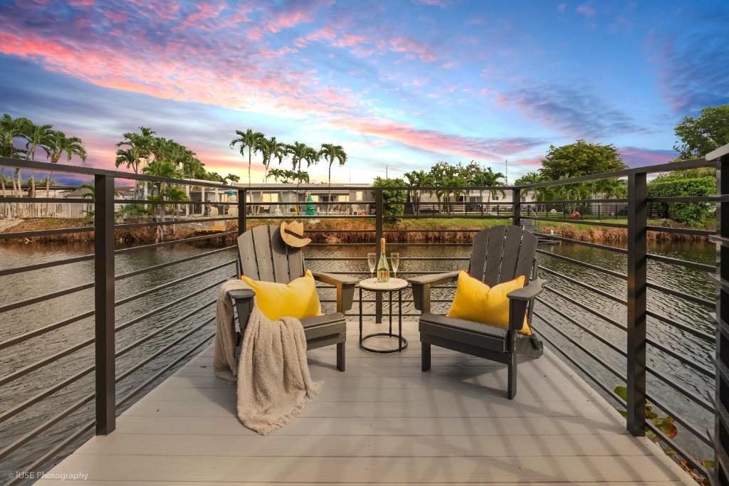d'un balcon avec deux chaises et une table. dans l'établissement The World Mansion 22 Guest Heated Pool Canal View, à Tamiami