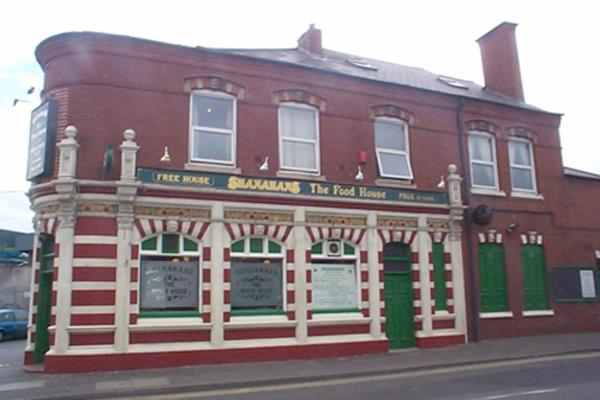 a red brick building with green and white trim at Shanahans B&B with Sports Bar in Birmingham