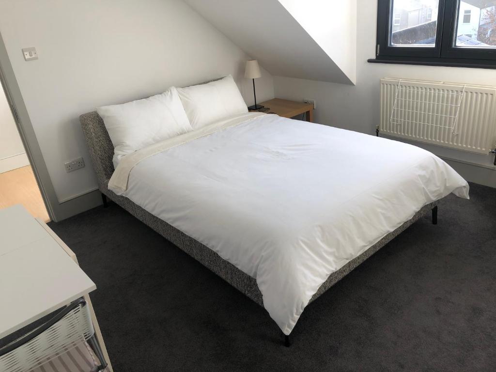 a bedroom with a large white bed with white sheets at Perfect Pad for Solo Travelers in Norwood