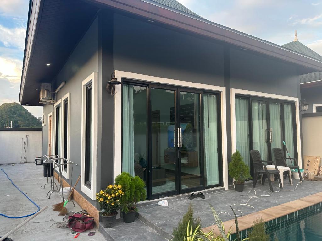 une maison avec des portes coulissantes en verre sur une terrasse dans l'établissement Luxury Private Pool Villa- Ao Nang Krabi, à Ao Nam Mao