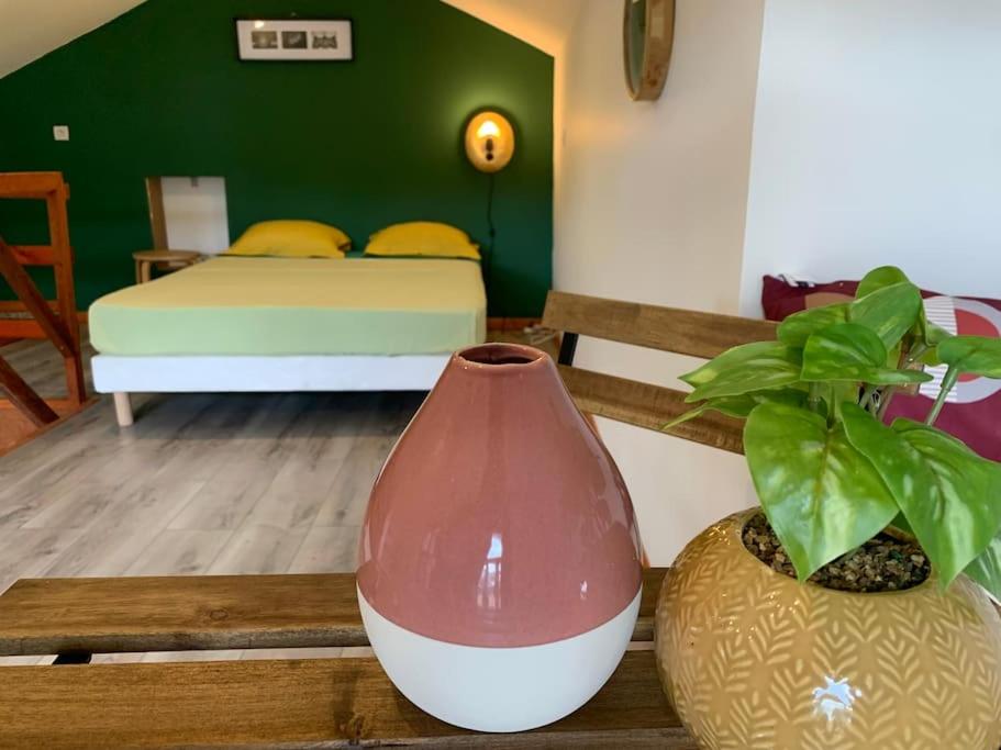 een kamer met een bed en een vaas met een plant bij Appart des airs Mamoudzou in Mamoudzou
