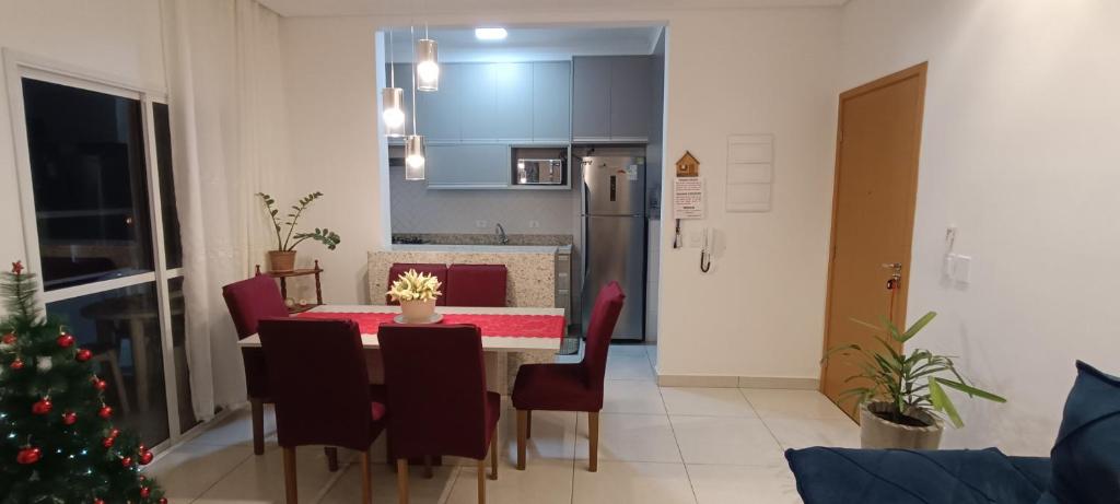eine Küche und ein Esszimmer mit einem Tisch und einem Weihnachtsbaum in der Unterkunft Apartamento Atos Ubatuba in São Paulo
