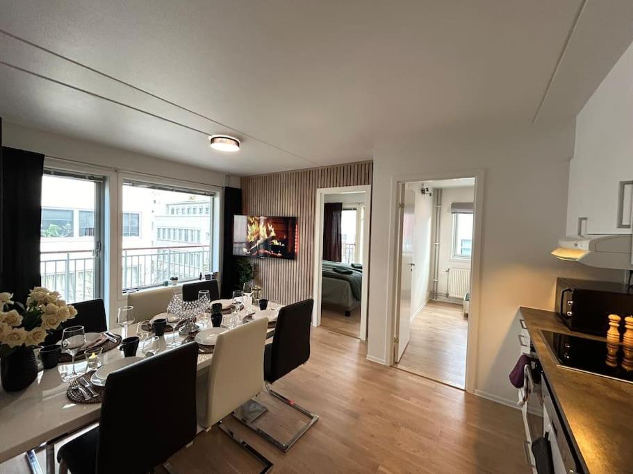 ein Esszimmer mit einem Tisch und Stühlen sowie ein Wohnzimmer in der Unterkunft Luxurable super central 3 BR apt for a family of 6 in Oslo in Oslo