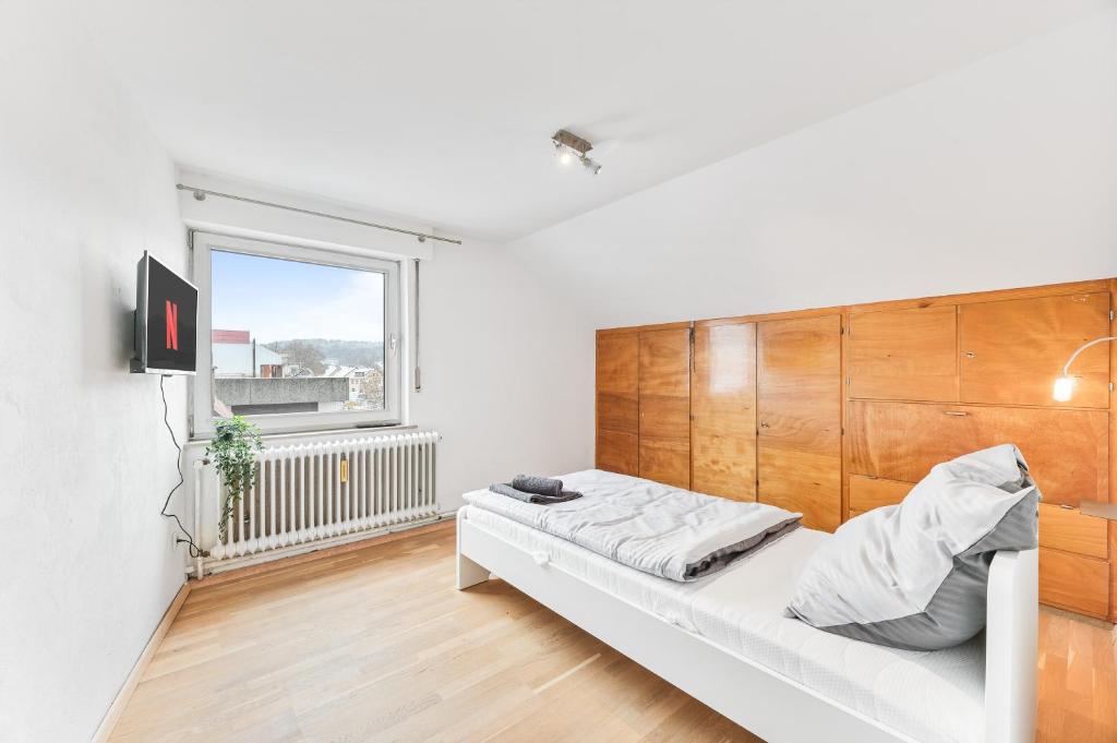 een witte kamer met een bed en een raam bij MONTEURWOHNUNG in Ebersbach EB01 RAUMSCHMIDE Apartments in Ebersbach an der Fils