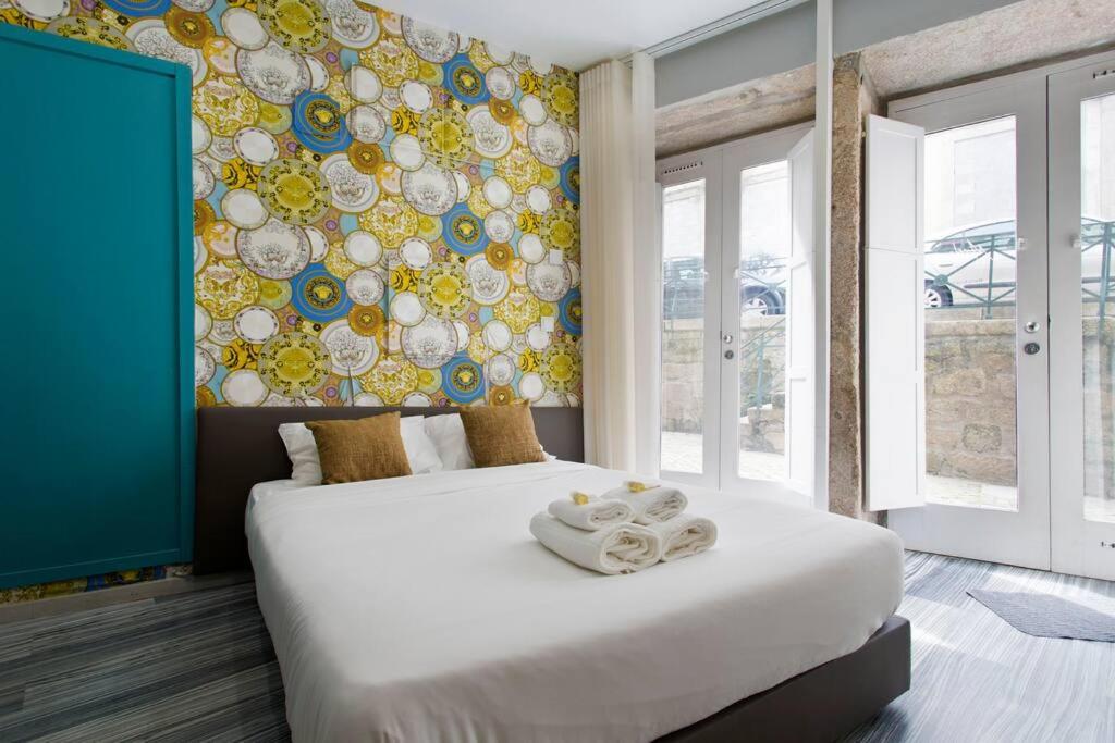 um quarto com uma cama grande e uma parede colorida em Aposentus - St Francisco Studio 20 no Porto