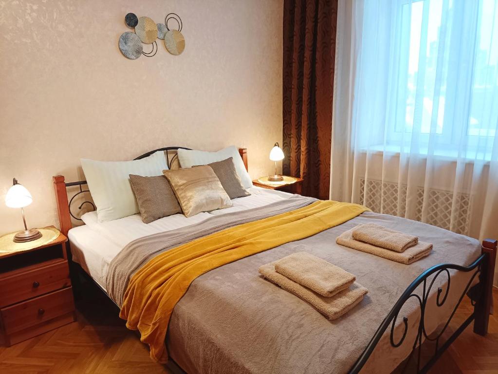 a bedroom with a large bed with two towels on it at Old Town Retreat with Stunning Views 2 bedroom Apartment in Riga