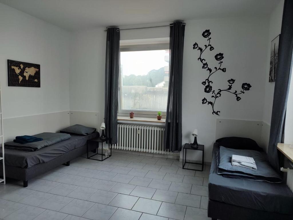 ein Wohnzimmer mit 2 Betten und einem Fenster in der Unterkunft Monteurwohnung 6 P. Mönchengladbach Rheydt in Mönchengladbach