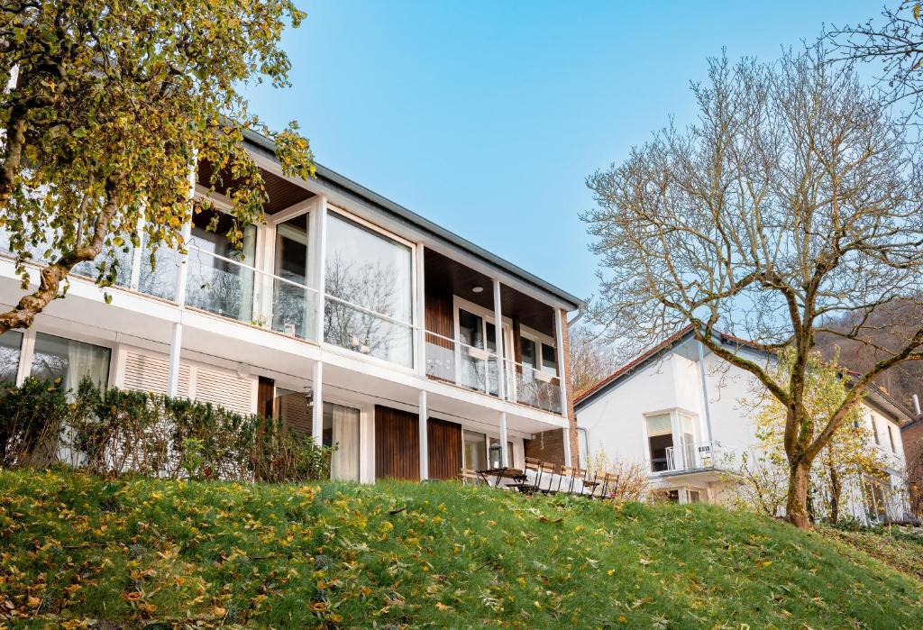 ein großes weißes Gebäude mit Balkon auf einem Hügel in der Unterkunft Villa Plesse - exklusiv und geräumig wohnen nahe Göttingen in Bovenden