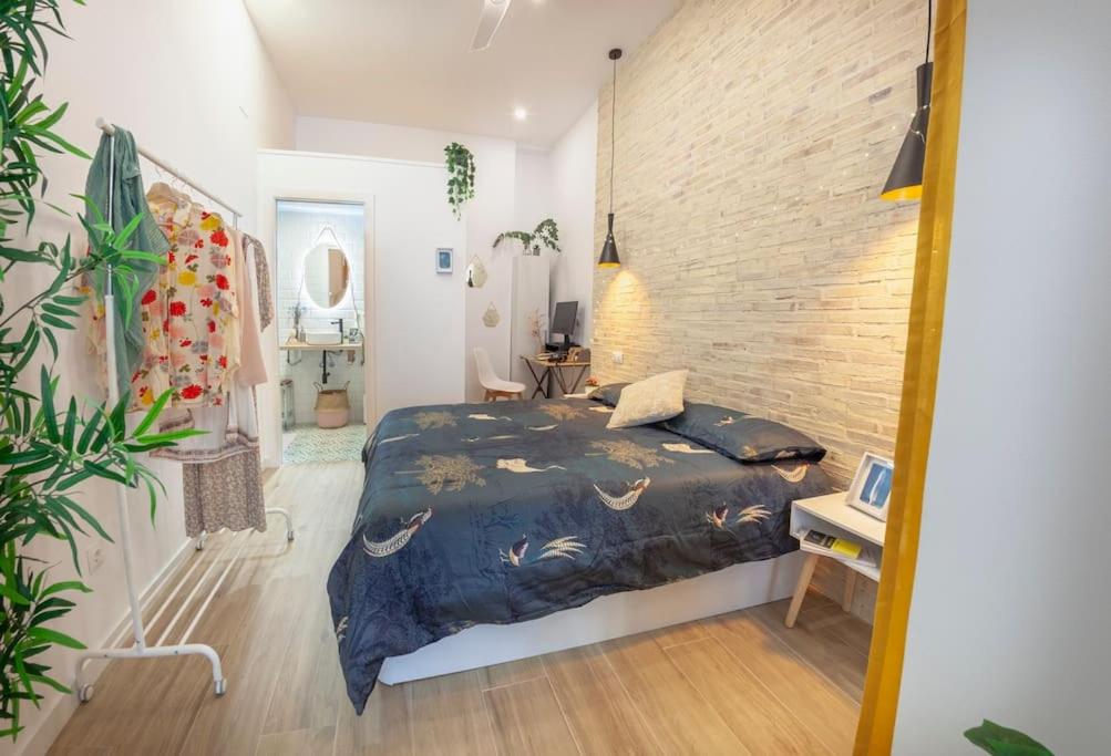1 dormitorio con cama y pared de ladrillo en Artistic Designer Getaway - Digital Nomads + Couples, en Valencia