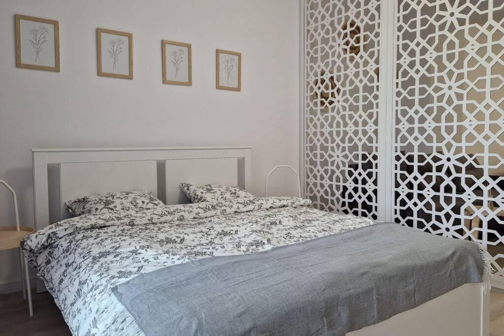 a white bedroom with a bed with a headboard at Lovely apartment in City Center in Timişoara