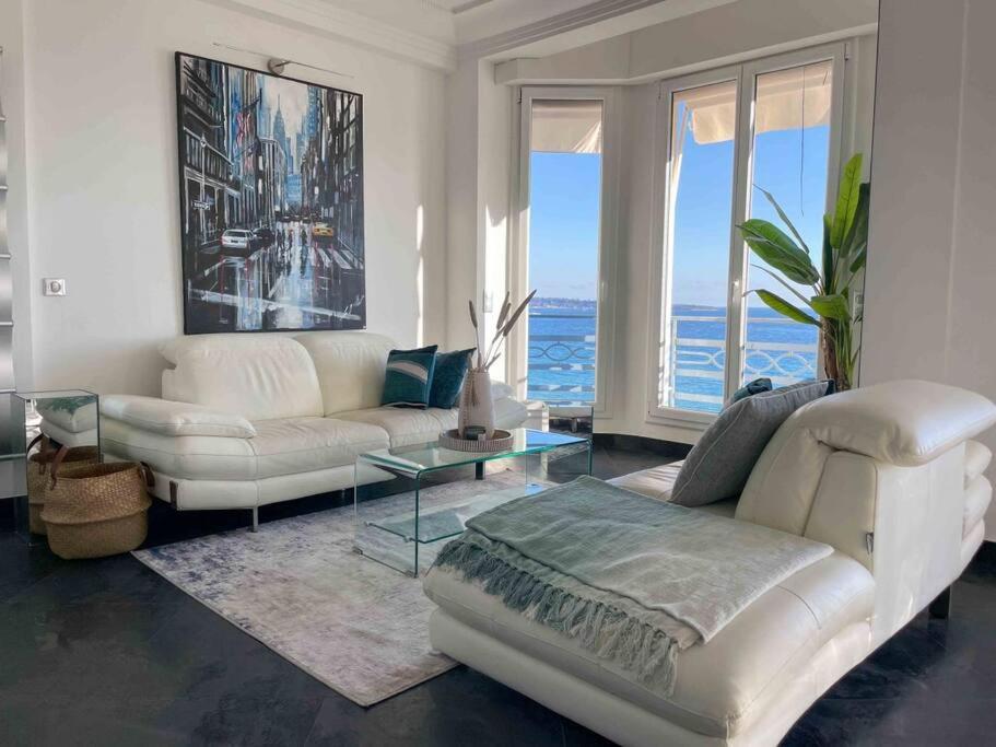 un salon avec un canapé blanc et une table dans l'établissement Stunning 2 bedroom flat with sea view on Croisette, à Cannes