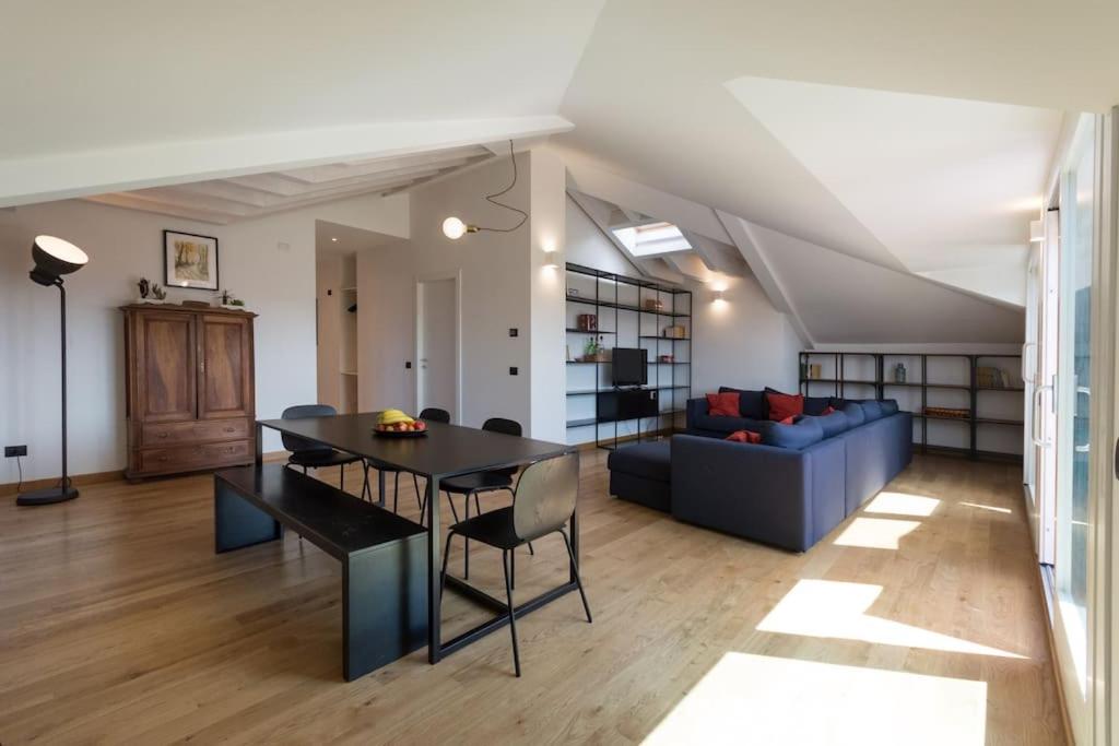 een woonkamer met een tafel en een blauwe bank bij attico in un'oasi di verde sui navigli in Milaan