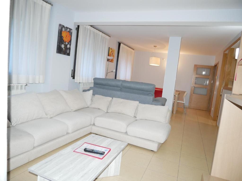 a living room with a white couch and a table at Saüc-Vacances Pirinenca in Canillo