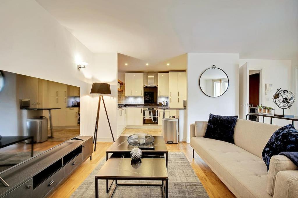 een woonkamer met een bank en een tafel bij Radiant 2BR Tower Bridge Oasis with Rooftop Deck in Londen