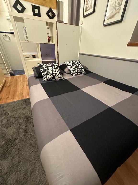 Una cama en blanco y negro en una habitación en Petit house city center en Madrid