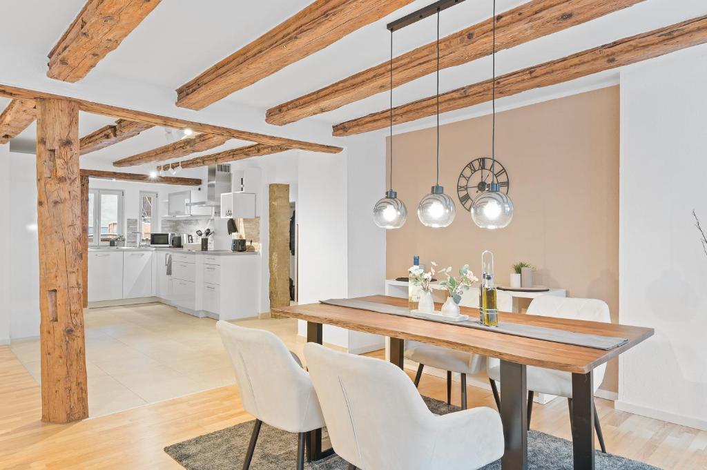 a dining room with a wooden table and white chairs at TOP Apartments - Moderne Altbauwohnung im Zentrum Ludwigsburg - Kingsize Bett - Netflix - 80qm - 24h Check-In in Ludwigsburg