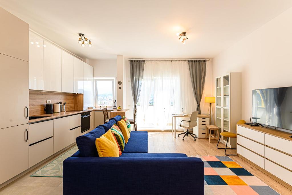 un soggiorno con divano blu e una cucina di Coresi Mountain View Brasov City a Braşov
