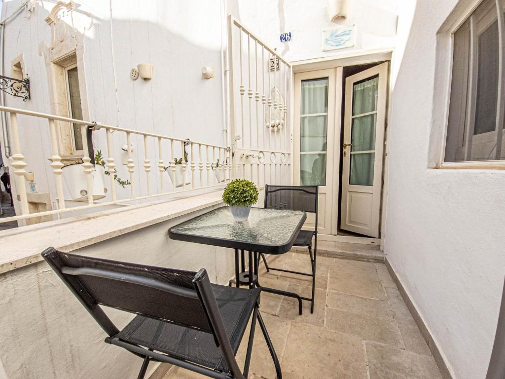 un pequeño balcón con mesa y sillas. en Martine Dimore Storiche di Puglia, en Martina Franca