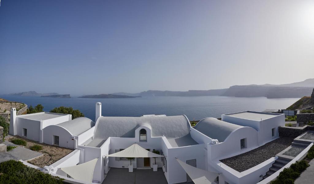 ein weißes Haus mit Blick auf das Wasser in der Unterkunft Akrotiri Private Residence in Fira