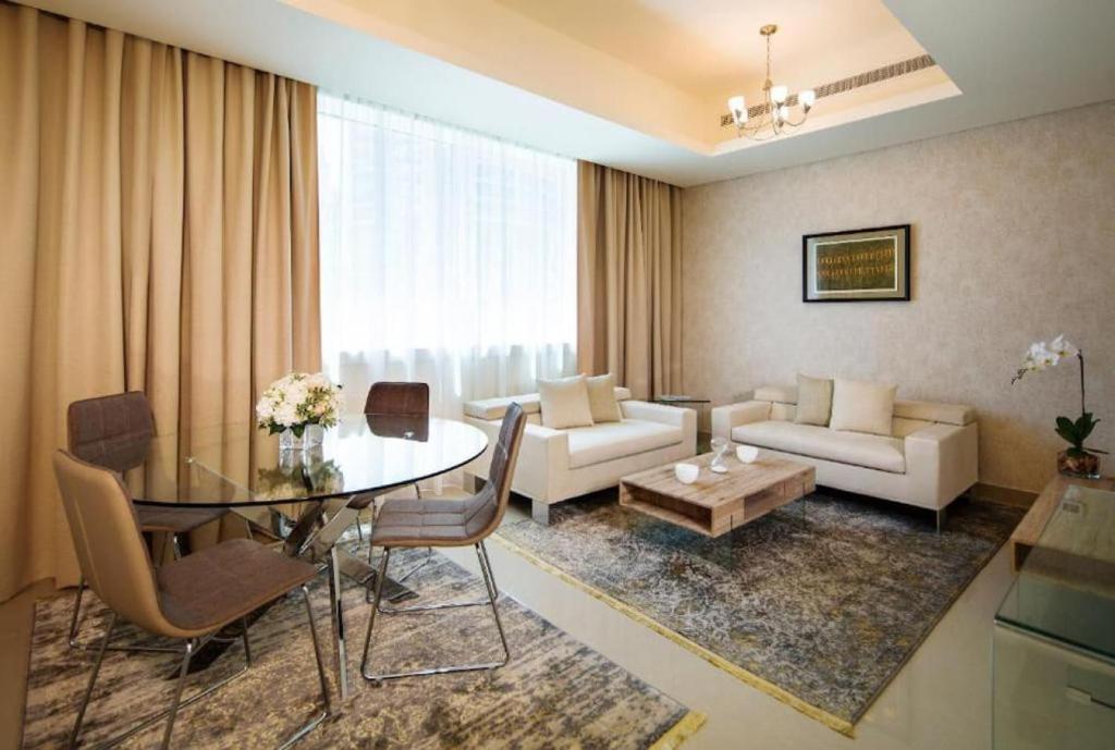 Marina One Bedroom - KV Hotels في دبي: غرفة معيشة مع طاولة وأريكة