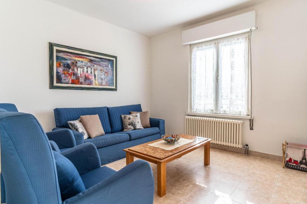 ein Wohnzimmer mit blauen Sofas und einem Couchtisch in der Unterkunft Casa Maggiorina, Levico Terme Ospitar in Levico Terme