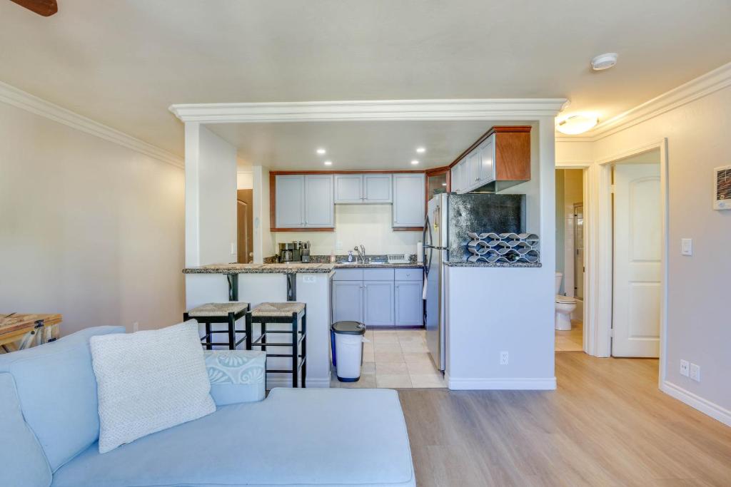 a living room with a blue couch and a kitchen at Sunny Imperial Beach Condo - Walk to Ocean! in Imperial Beach