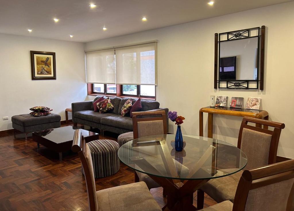 uma sala de estar com uma mesa de vidro e um sofá em Luxury Apartment Barranco Malecon em Lima