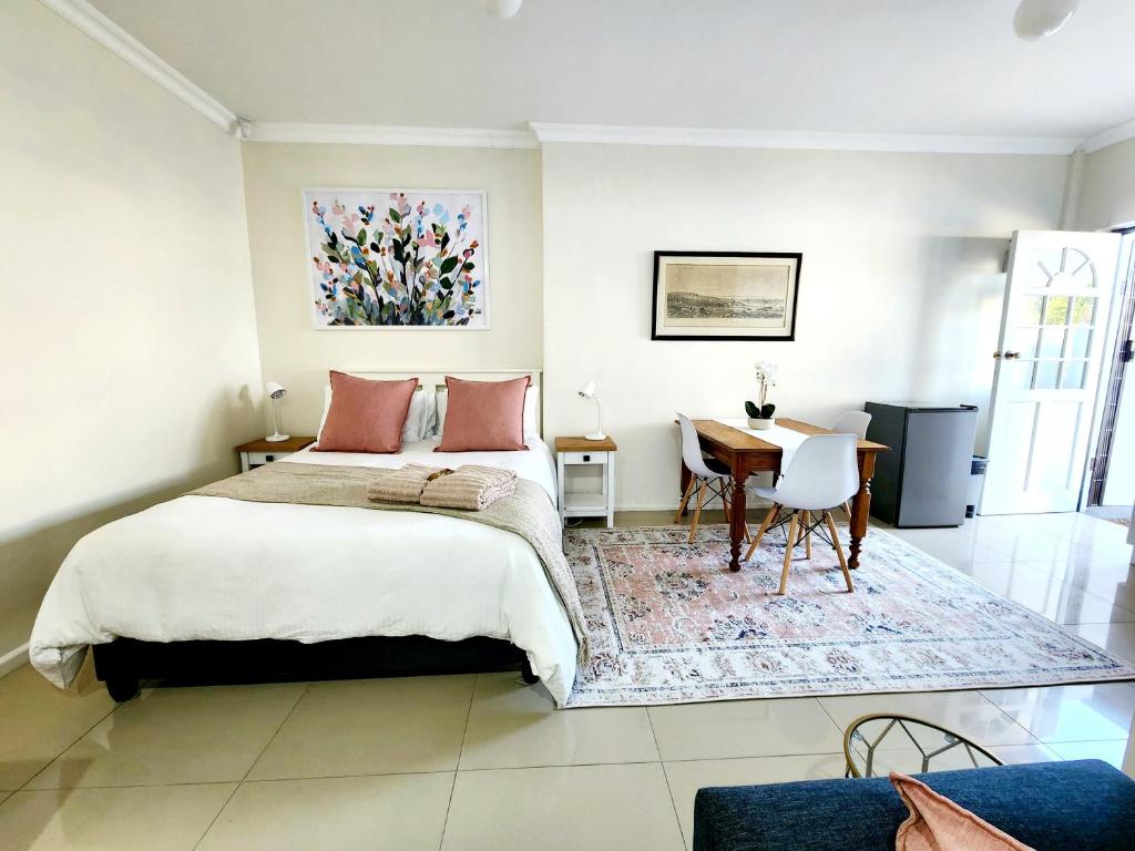 a bedroom with a large bed and a desk at Bayside Bliss Studio Apartment in Summerstrand