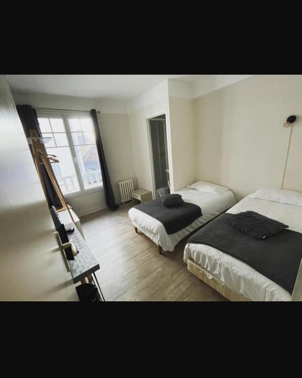 a bedroom with two beds and a window at Les Chiens du Guet in Saint Malo