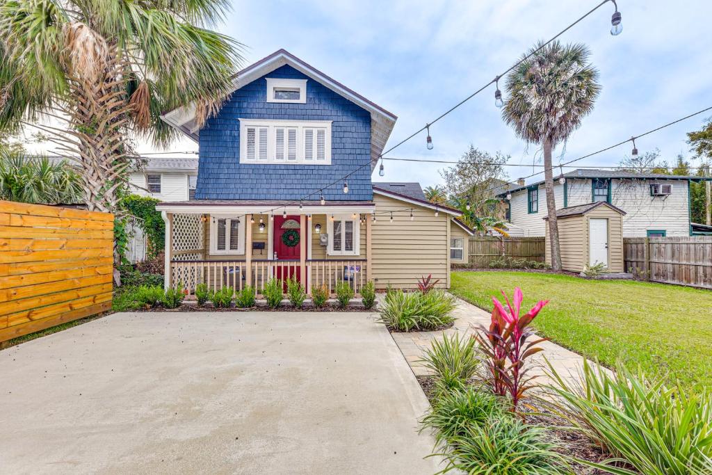 a blue house with a red door in a yard at Cozy Jacksonville Cottage, Walkable Location! in Jacksonville