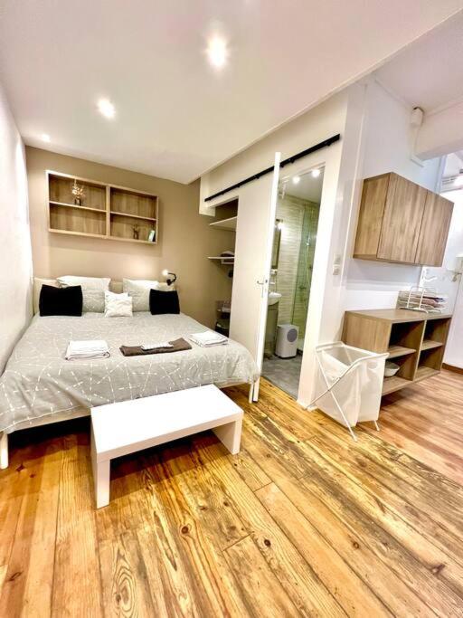 une chambre avec un grand lit avec un plancher en bois dans l'établissement Studio quartier prisé des Carmes, à Toulouse