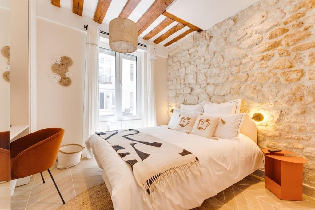 a bedroom with a bed and a stone wall at Opera Hypercenter, Spa & 3 Bedrooms 6 people in Paris