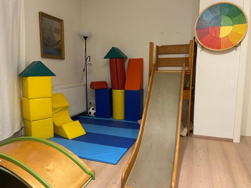 Villa Kinderbunt Linz في لينز: غرفة لعب مع سلم وبيت العاب