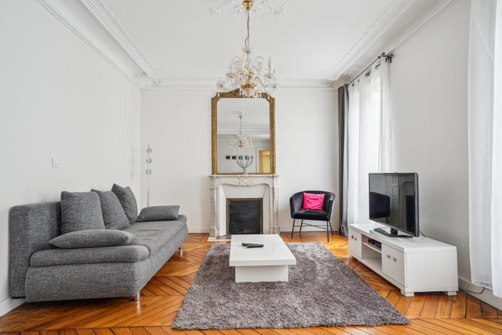 a living room with a couch and a tv at Luxury Apartment La Tour Paris in Paris