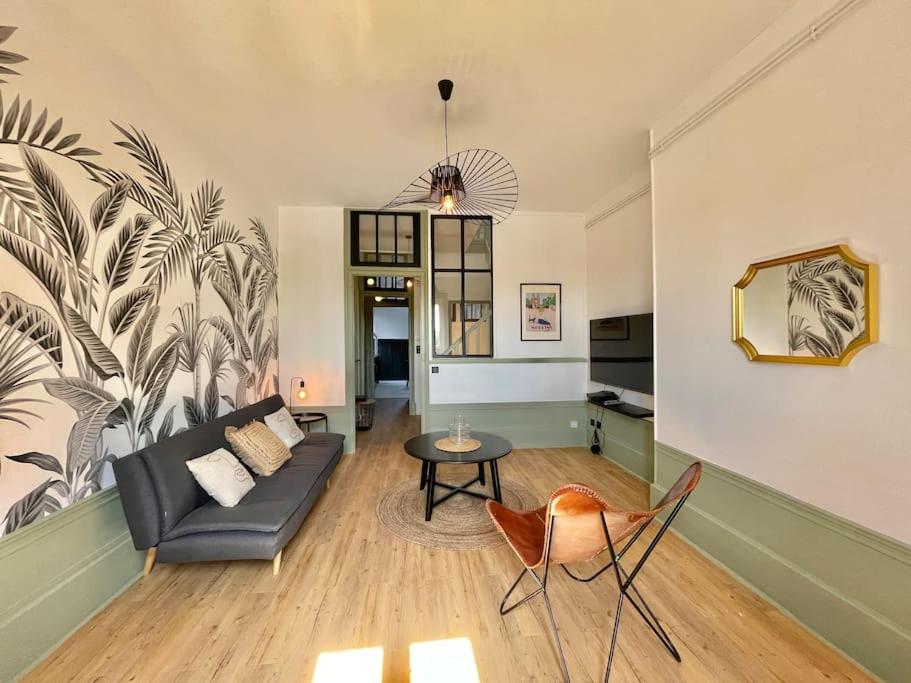 ein Wohnzimmer mit einem Sofa und einem Tisch in der Unterkunft Duplex de caractère 50 m² in Moulins