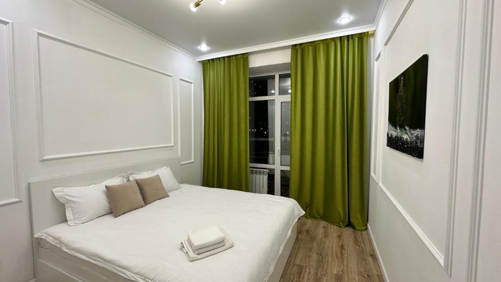 a bedroom with a bed with a green curtain at Stay Inn - 2-х комнатная квартира комфорт класса in Taldykolʼ