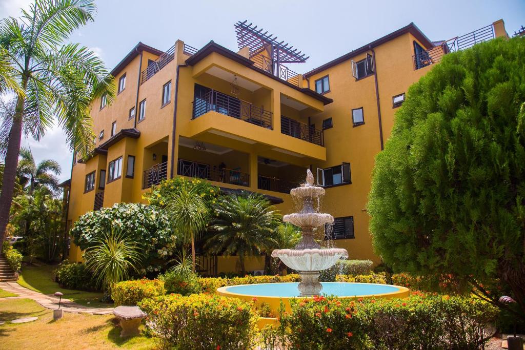 a building with a fountain in front of a building at MARIBELLA@CRYSTAL COVE OCHO RIOS in Stanmore Grove