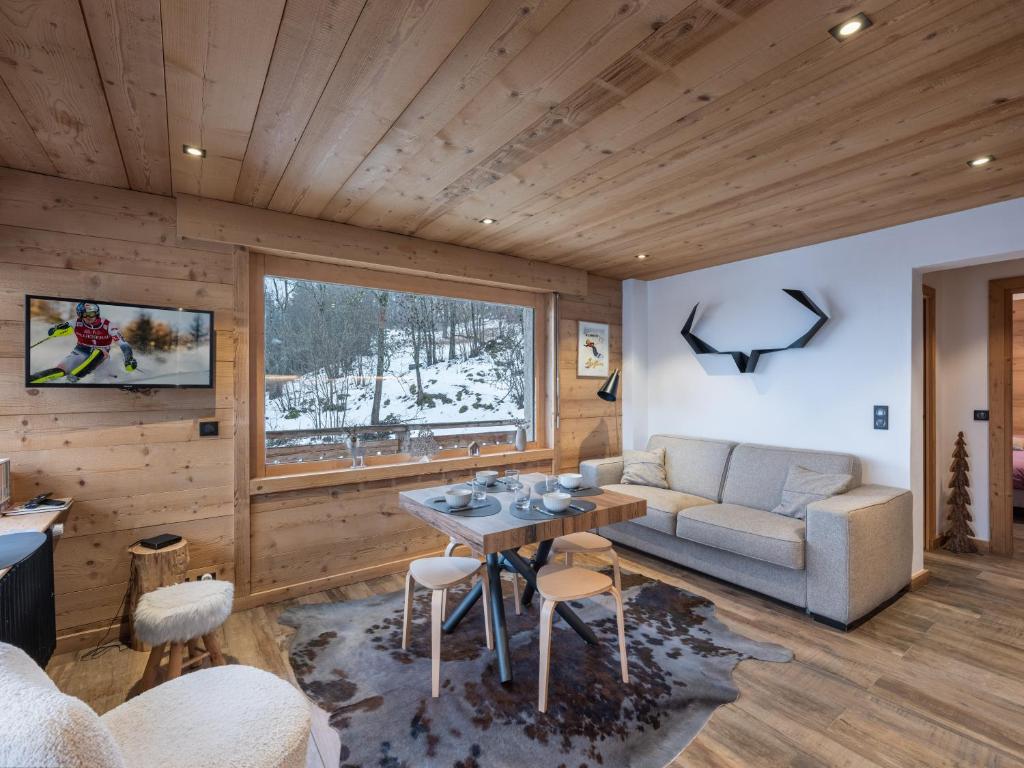 a living room with a couch and a table at CHALET " JEANE " proche centre in Megève