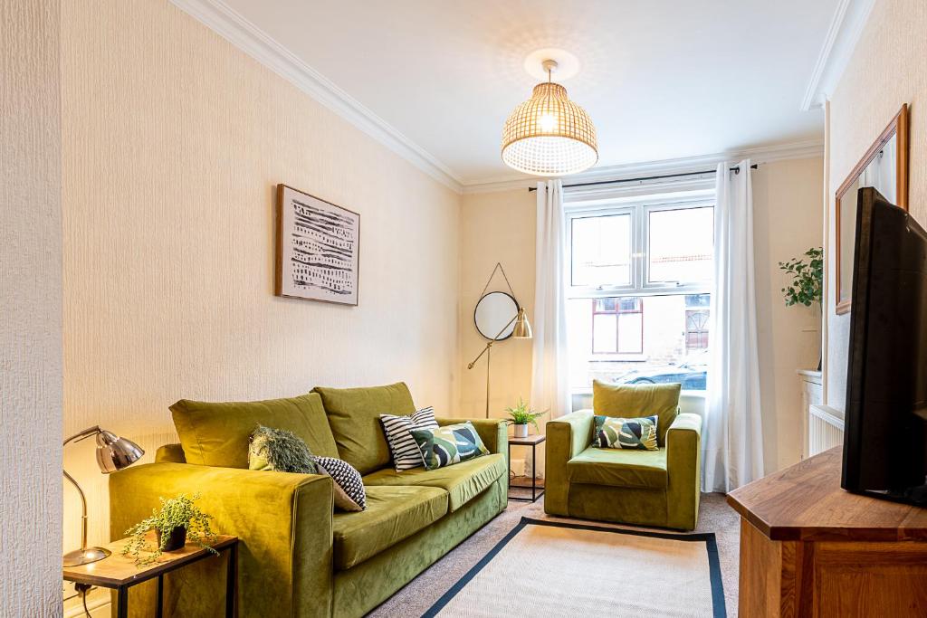 a living room with a yellow couch and a chair at 2 bed, up to 6 guests near Chester City Centre in Chester