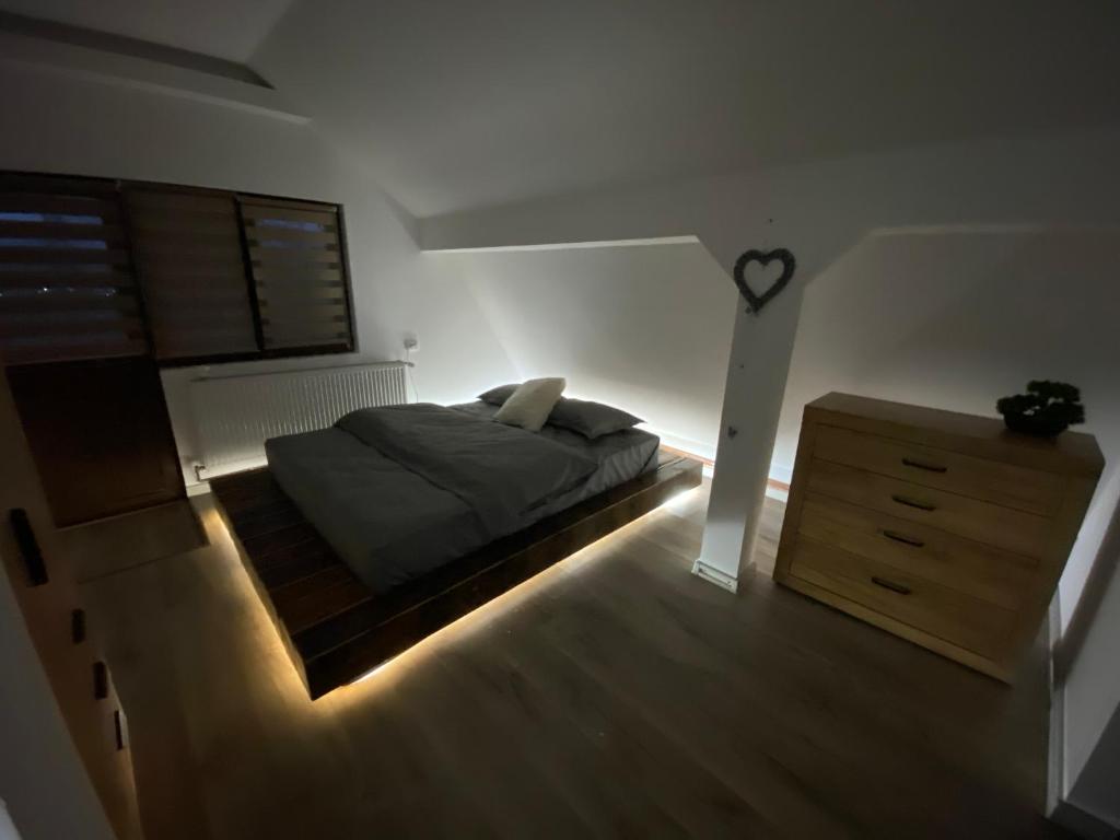 sypialnia z łóżkiem i drewnianą komodą w obiekcie Bob’house w mieście Vulcan
